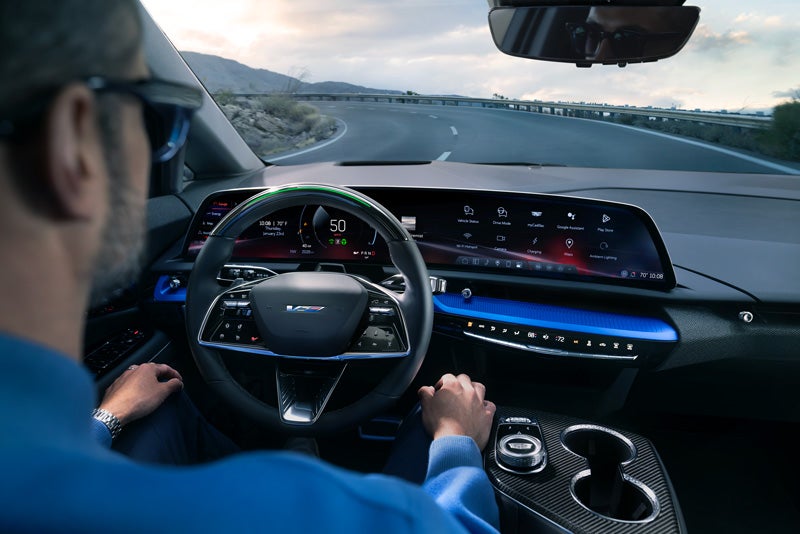 Front View of the 2026 OPTIQ-V Driving Through the Dusk Utilizing its Headlights | Ed Morse Cadillac Tampa FL in TAMPA FL