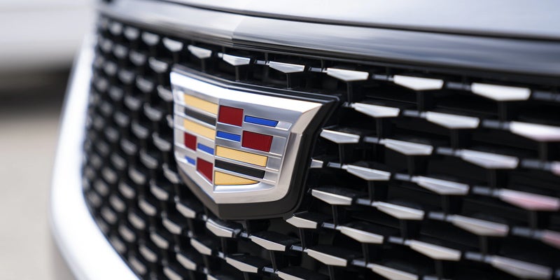 Close-up of the Cadillac XT6 logo and grille, showcasing its bold design and signature styling