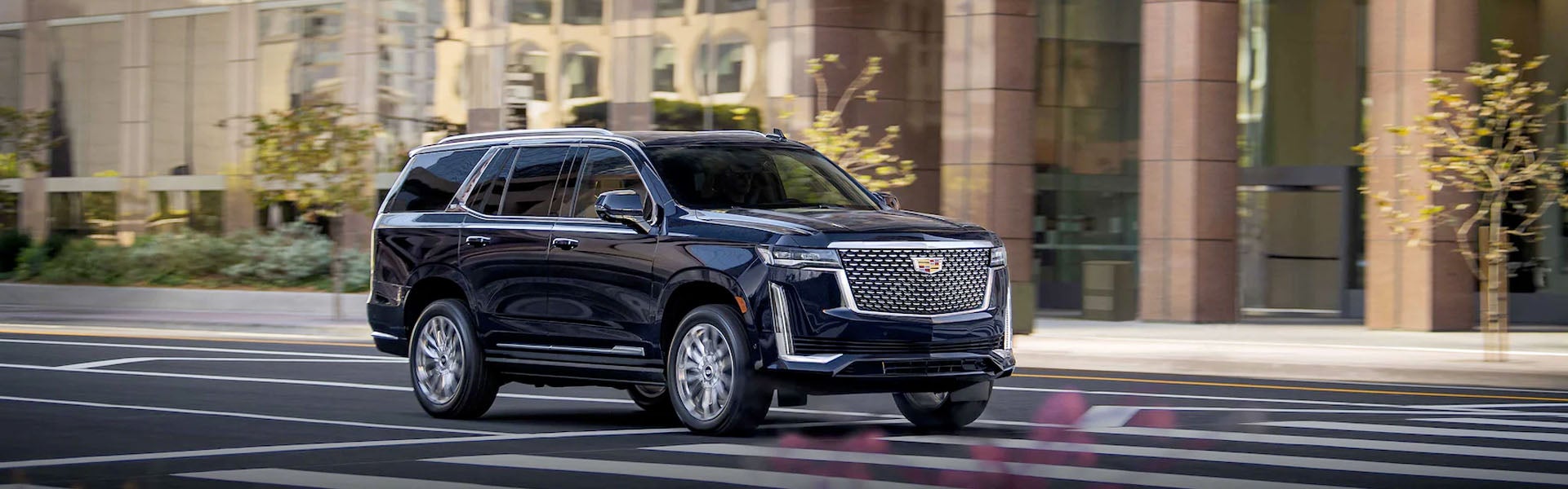 Cadillac Escalade driving on a road, highlighting its powerful presence and smooth performance